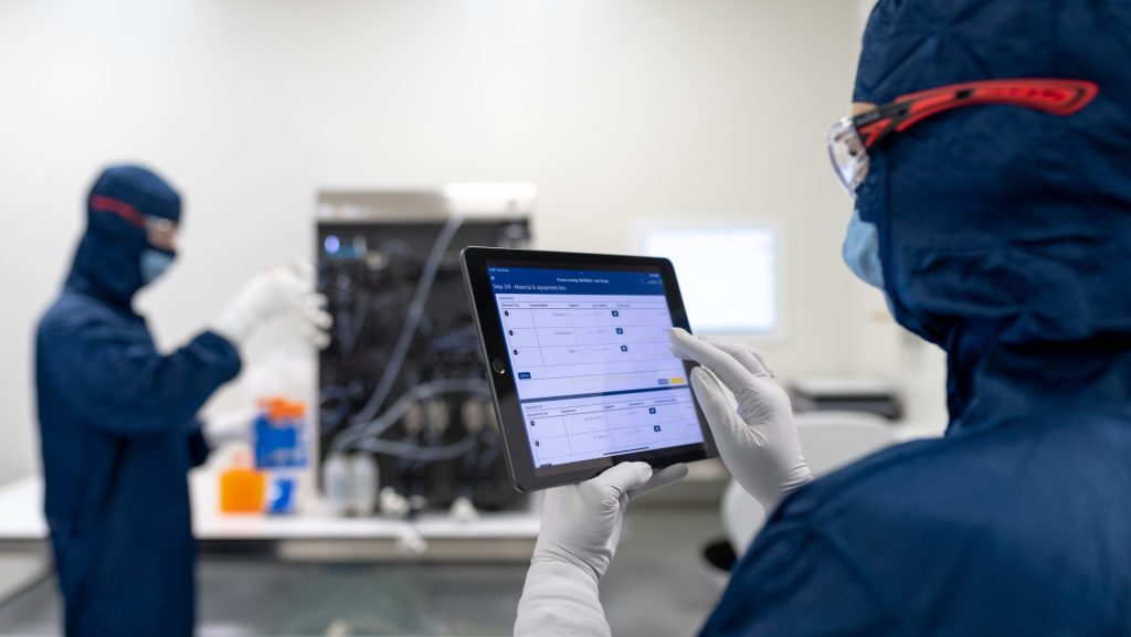a few people in protective gear using a computer
