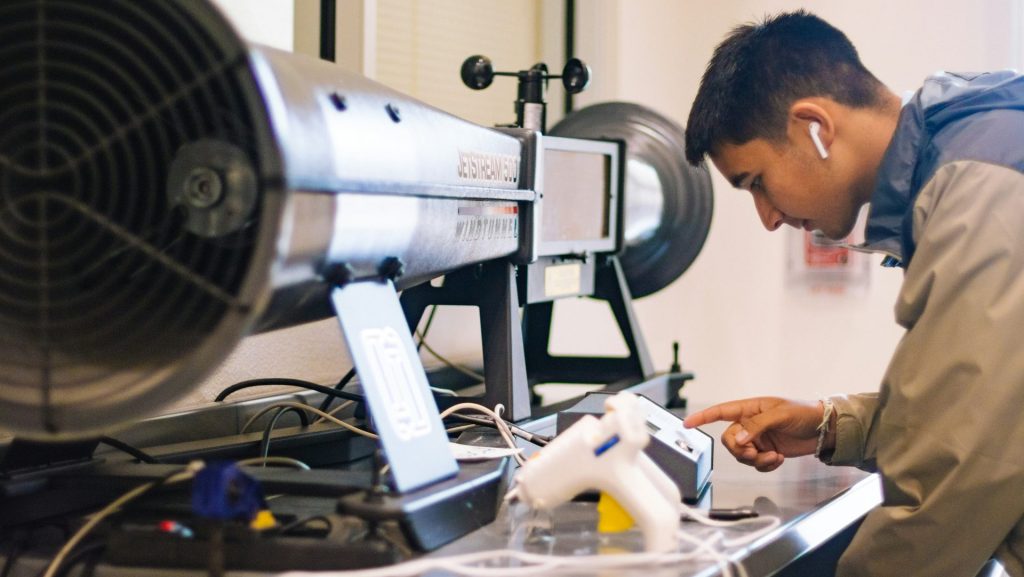 man in white crew neck t-shirt holding white smartphone